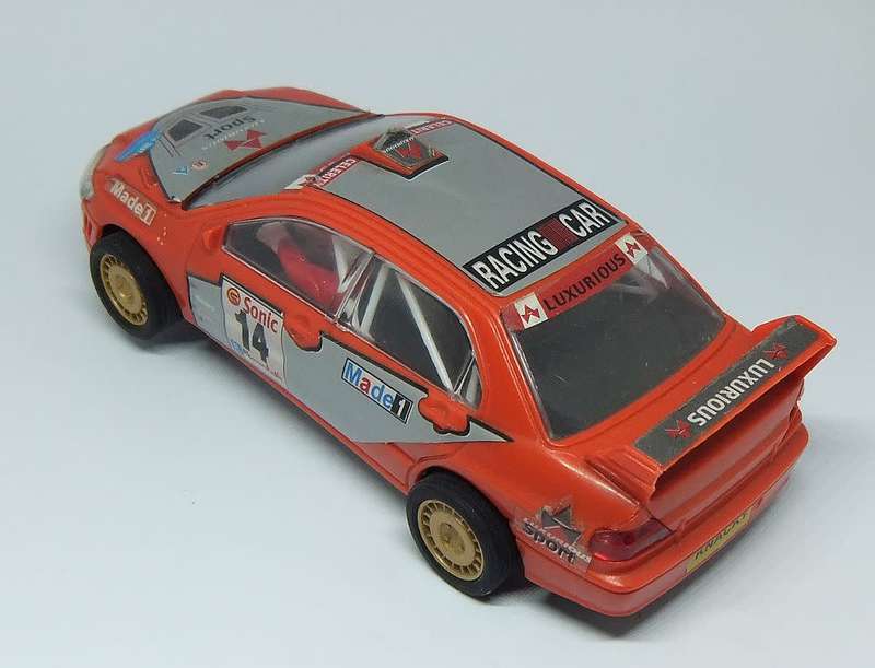 A vintage scalextric car with advertising , driver with co-driver aka navigator