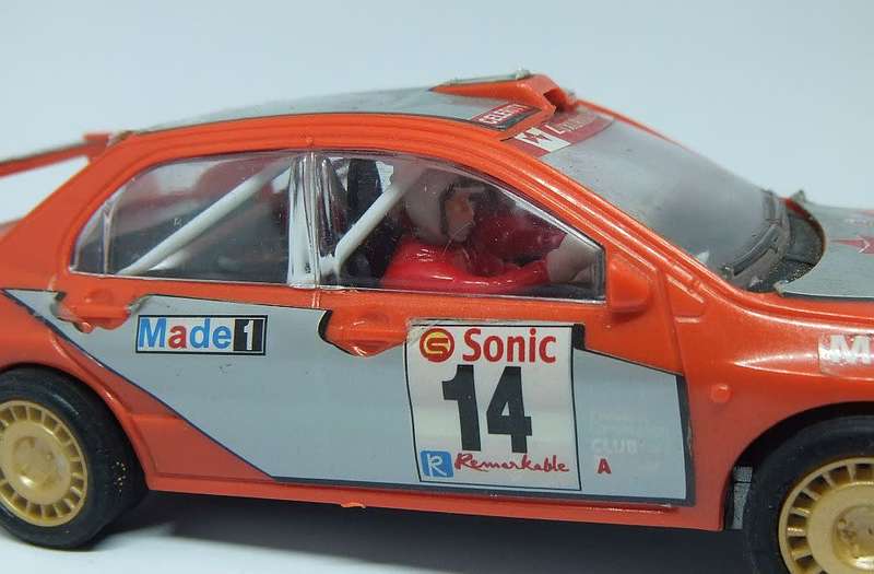 A vintage scalextric car with advertising , driver with co-driver aka navigator