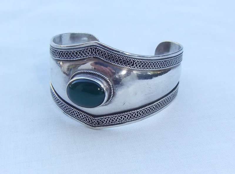 A solid sterling silver cuff bangle with a green cabochon inset - stamped & tested
