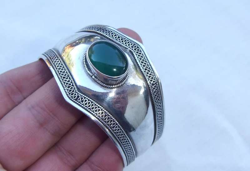 A solid sterling silver cuff bangle with a green cabochon inset - stamped & tested
