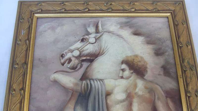 An eye catching framed oil painting depicting a man with a raging horse