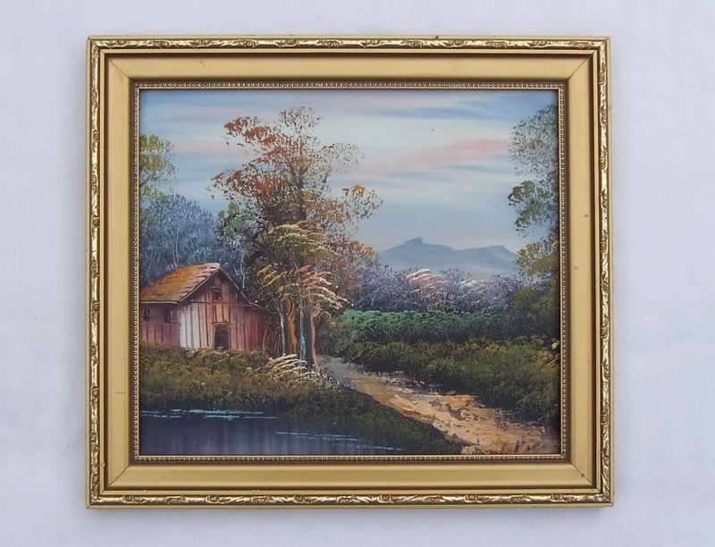 A CHARMING SIGNED OIL ON BOARD PAINTING DEPICTING A COTTAGE IN THE FORREST AT THE LAKE