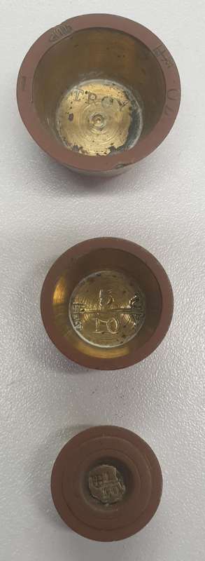 Antique 7 pce set of brass Troy ounce nesting cup weights.