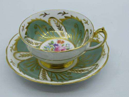 PARAGON VINTAGE GILDED AND SAGE-GREEN FOOTED TEA CUP AND SAUCER WITH CABBAGE ROSES.