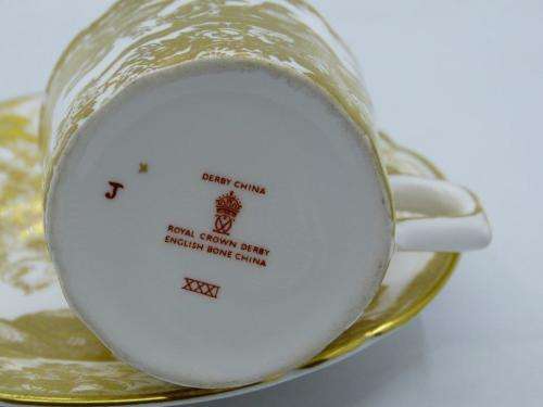 ROYAL CROWN DERBY DEMI TASSE AND SAUCER IN THE GOLD AVES  PATTERN.