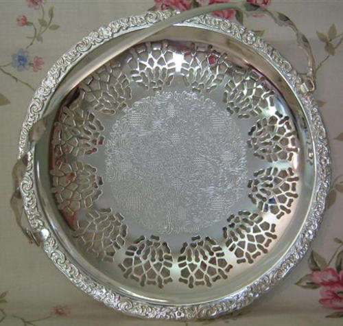 R1.00 SILVER PLATED CAKE BASKET WITH HANDLE, STANDING ON THREE BUN FEET. AS NEW CONDITION.