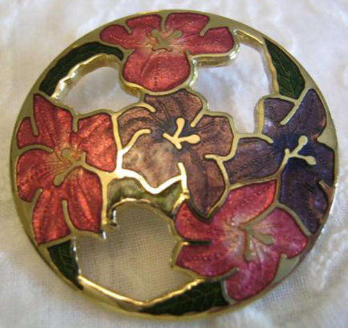 FLORAL, ENAMELED BROOCH WITH ROLL OVER CLASP, GILT SETTING IN GOOD CONDITION.