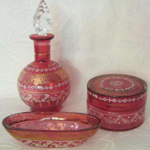 VINTAGE, THREE PIECE, DRESSING TABLE SET IN CRANBERRY GLASS, HAND PAINTED FLORAL AND GOLD DETAIL.