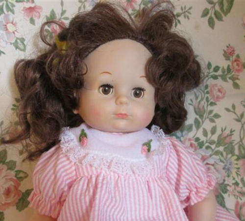 PRETTY AND VINTAGE RUBBER DOLL WITH LONG HAIR, LIMBS AND HEAD ARE RUBBER AND THE BODY FABRIC.