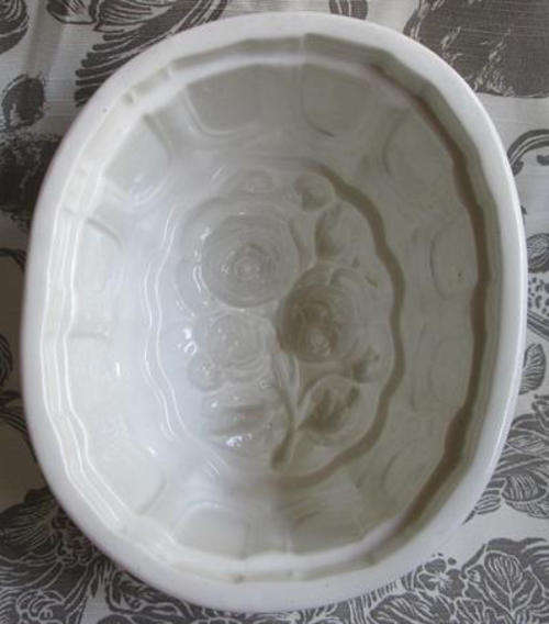 WHITE HEAVY PORCELAIN ANTIQUE JELLY MOULD WITH A ROSE DESIGN