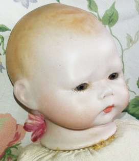 BABY DOLL WITH A PORCELAIN HEAD AND HANDS, A CLOTH BODY THAT NEEDS A GENTLE WASH, NO DAMAGE TO PORCE