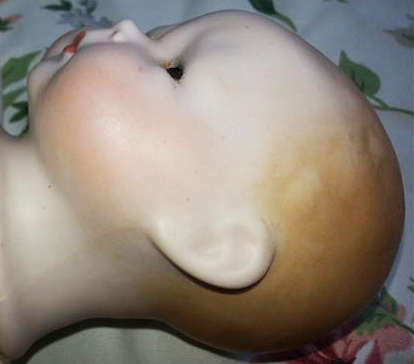 BABY DOLL WITH A PORCELAIN HEAD AND HANDS, A CLOTH BODY THAT NEEDS A GENTLE WASH, NO DAMAGE TO PORCE