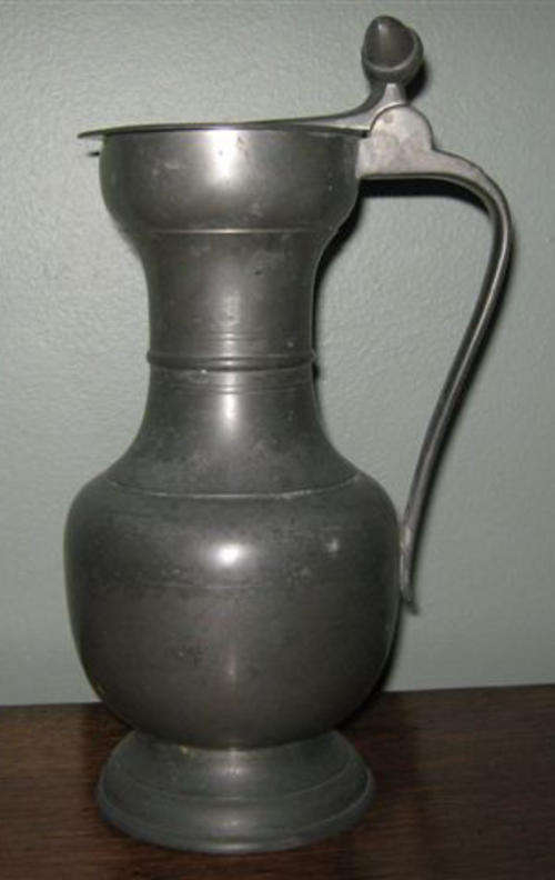 R1.00  ANTIQUE PEWTER JUG WITH LID DECORATED WITH 2 ACORNS. CONDITION GOOD.