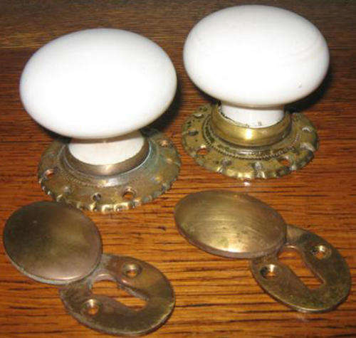 PAIR OF VINTAGE PORCELAIN AND BRASS DOOR HANDLES WITH KEY HOLE COVERS.