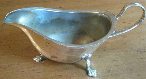 R1.00    " SHABBY CHIC "  SILVER PLATED GRAVY BOAT STANDING ON THREE LEGS WITH HANDLE.