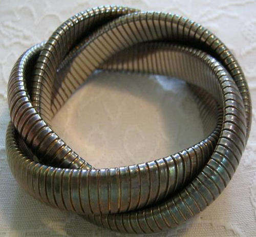 R1.00     INTERESTING METAL BANGLE, MADE OF THREE INTERLOCKING, FLEXABLE METAL BANDS.