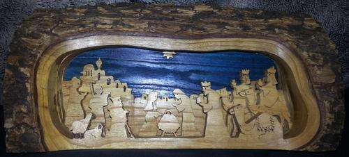 THE BIRTH OF JESUS IN THE STABLE CARVED OUT IN A LOG OF WOOD