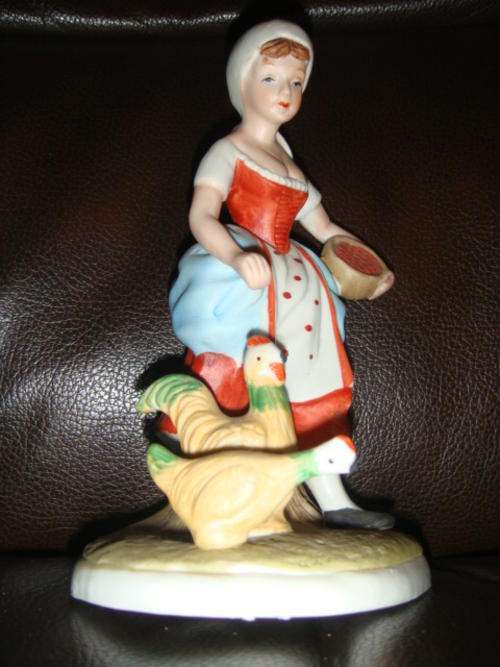 Ceramic woman figure feeding chickens