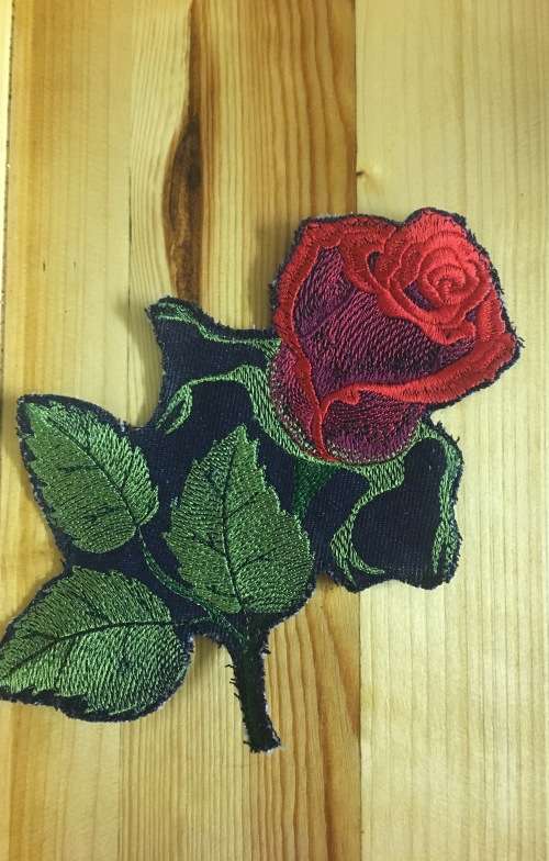Red and green rose bud badge patch