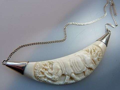 BONE/IVORY CARVED NECKLACE PENDANT ON STERLING SILVER CHAIN.