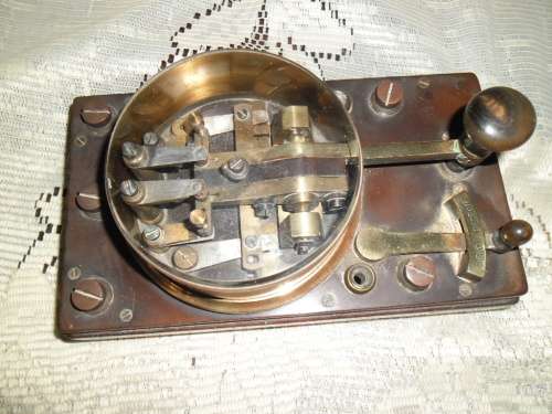 Brass and wood vintage Morse code telegraph key with glass cover