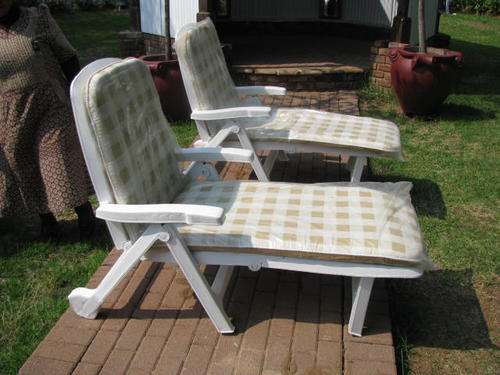 A PAIR OF POOL RECLINERS IN NEW CONDITION WITH CUSHIONS STILL WRAPPED IN PLASTIC