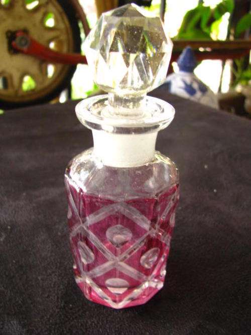 A VINTAGE PERFUME BOTTLE.......... PURPLE WITH GROUND GLASS STOPPER