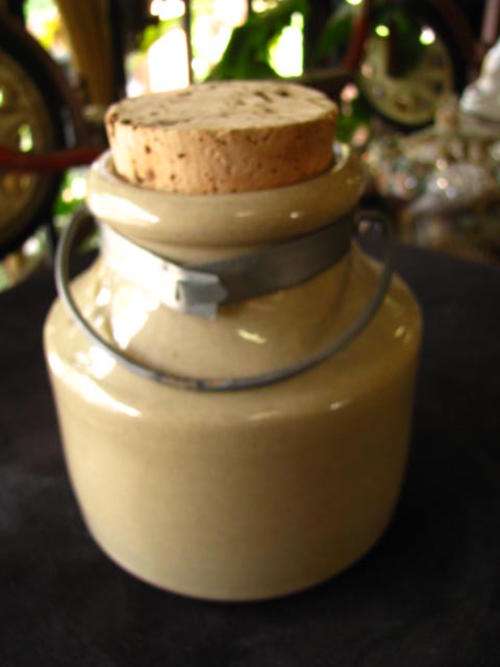 AN INTERESTING BEIGE JAR WITH METAL HANDLE AND CORK STOPPER