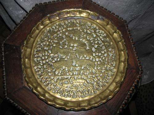 A BRASS ANTIQUE CHINESE PLATE WITH ANIMALS & BIRD MOTIF & SCALLOPED RIM