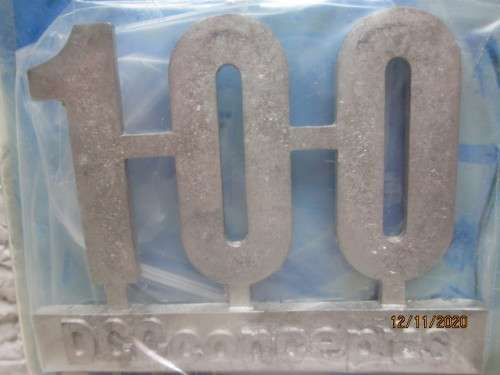 REDUCED TO CLEAR : DCC CONCEPTS : `100` WHITE METAL BADGE