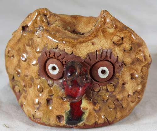 Brown owl with a red beak