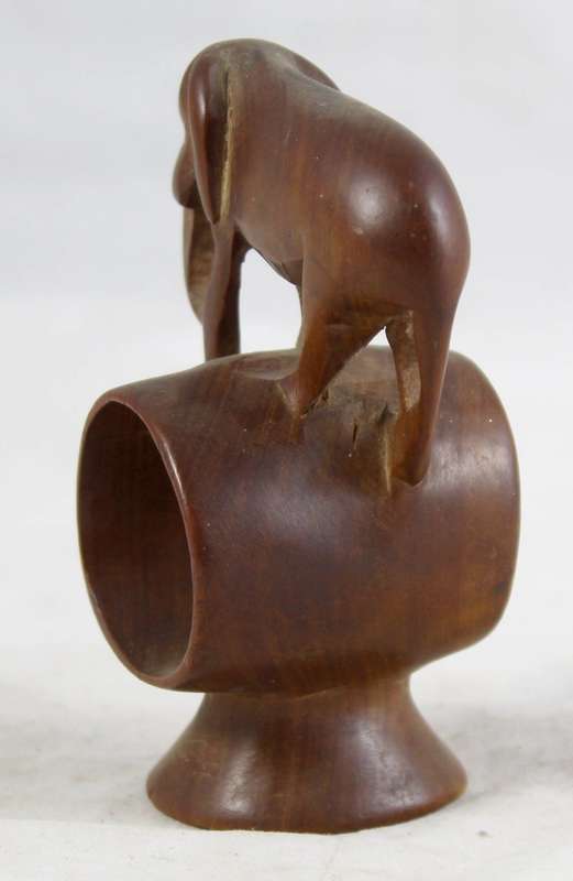 Carved wooden elephant on a barrel