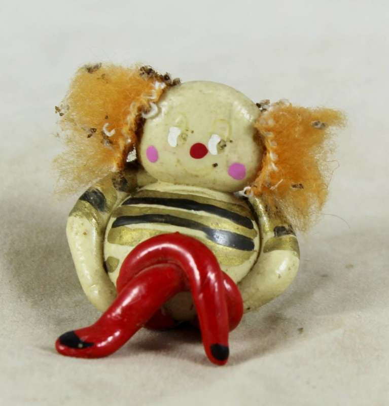 Miniature clown seated with crossed legs