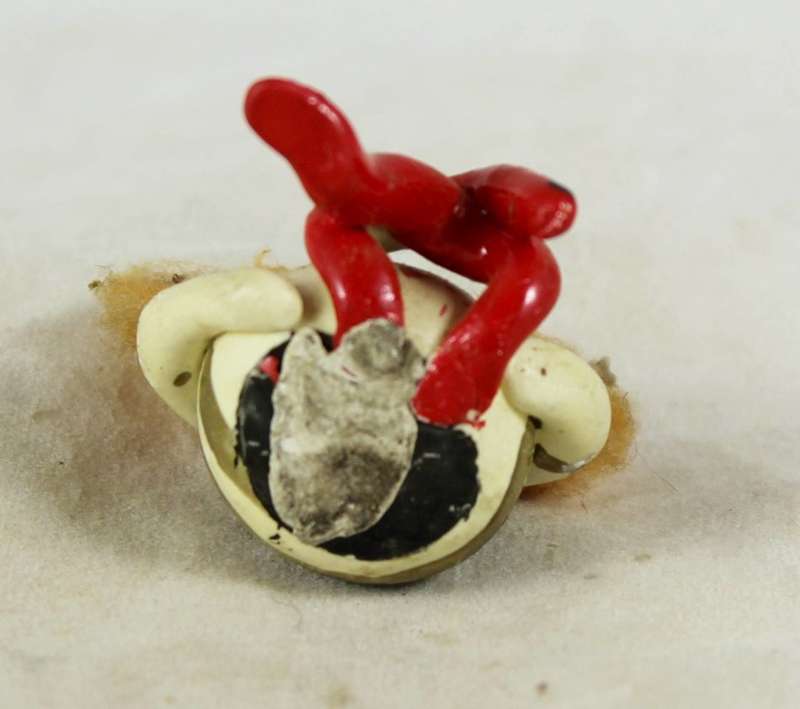 Miniature clown seated with crossed legs