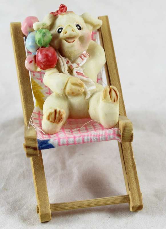 Pig with balloons - relaxing on beach chair