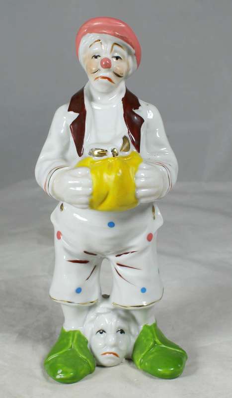 Clown with a head between feet