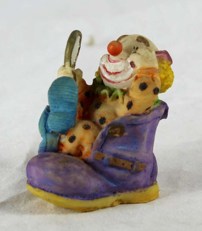 Small clown combing hair in shoe