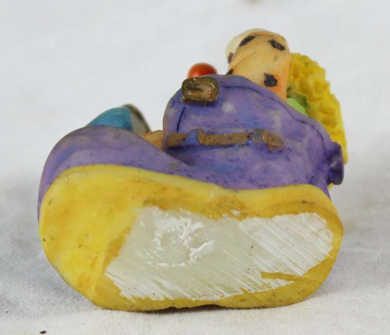 Small clown combing hair in shoe