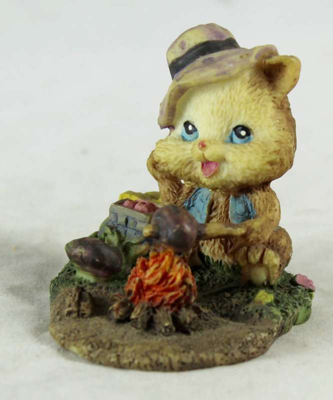 Small cat eating over a fire