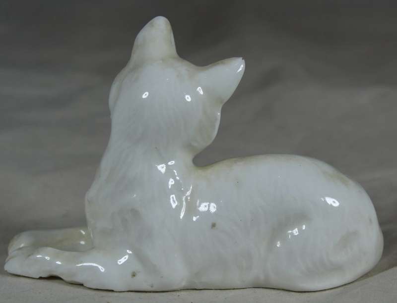 Porcelain small dog lying down