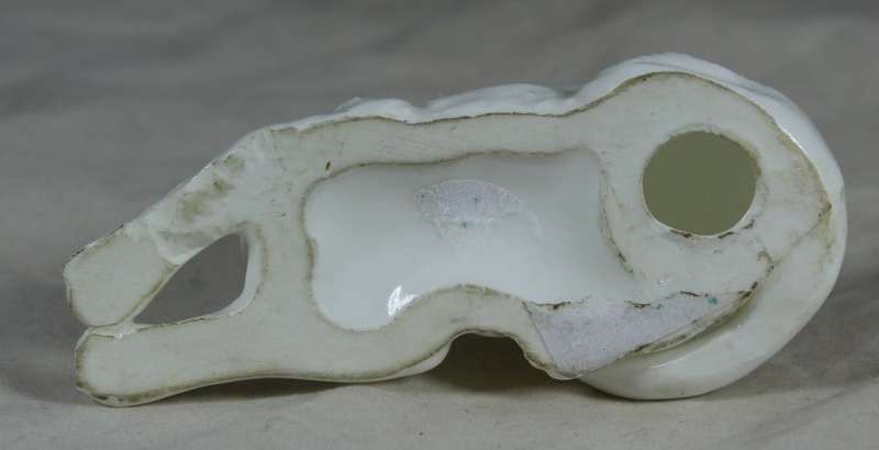 Porcelain small dog lying down