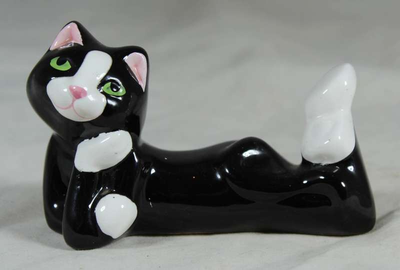 Funky porcelain cat lying down