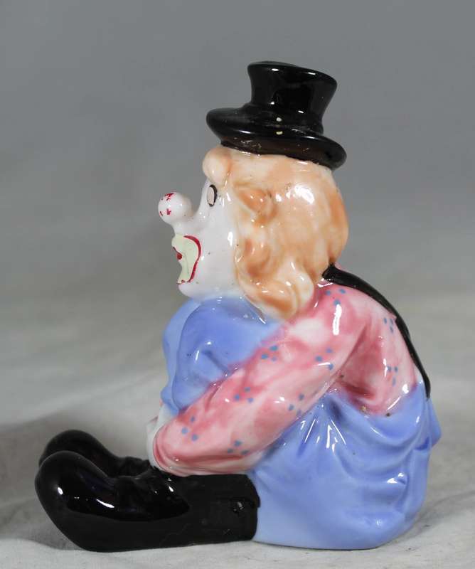 Seated clown with pulled up legs