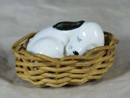 Porcelain puppy sleeping in a basket