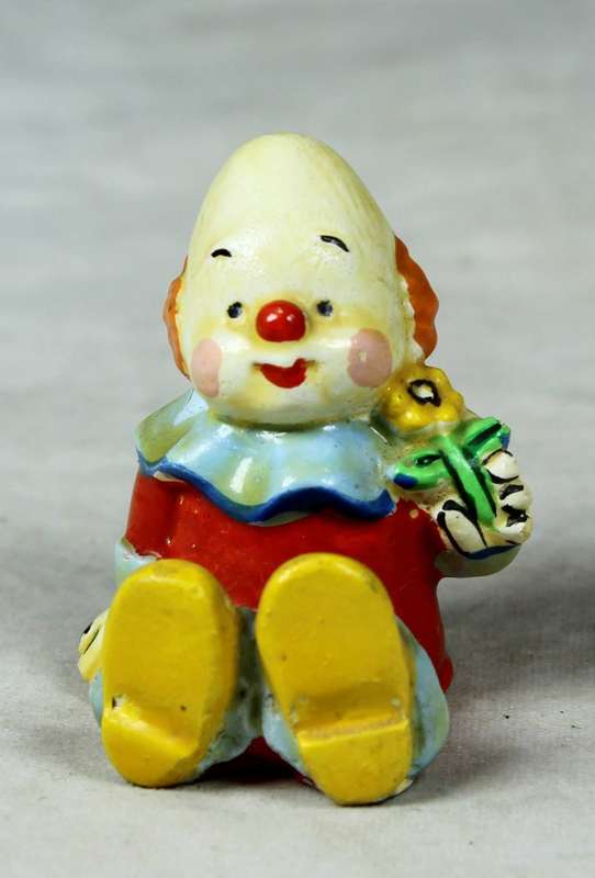 Miniature clown baby with a flower in his hand