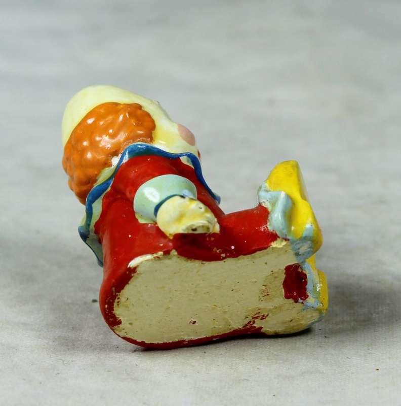 Miniature clown baby with a flower in his hand