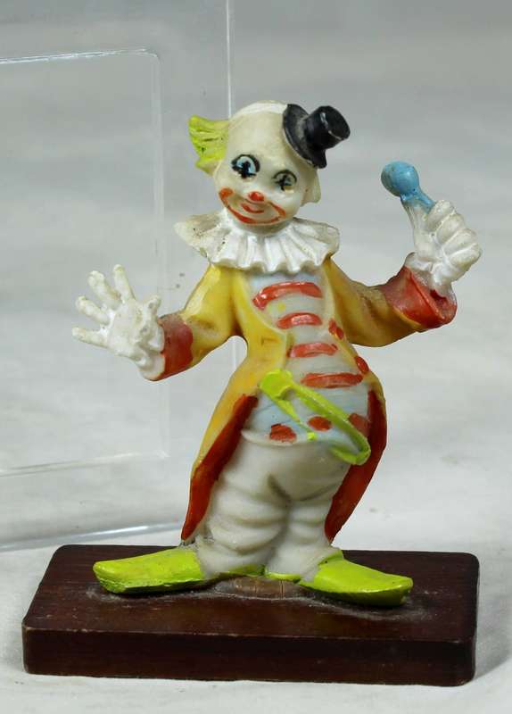Miniature clown with a large safety pin on a stand