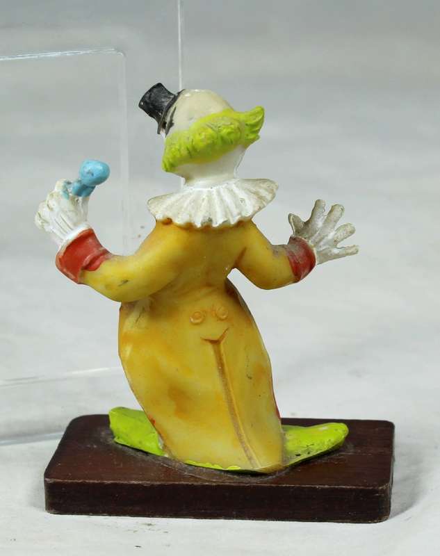 Miniature clown with a large safety pin on a stand