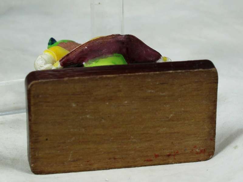 Miniature clown bowing down on a stand