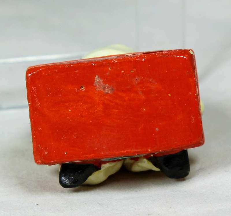 Miniature clown sitting on a chest